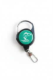 Retractable keychain with green label on a wooden surface