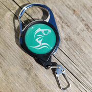 Retractable keychain with green label on a wooden surface