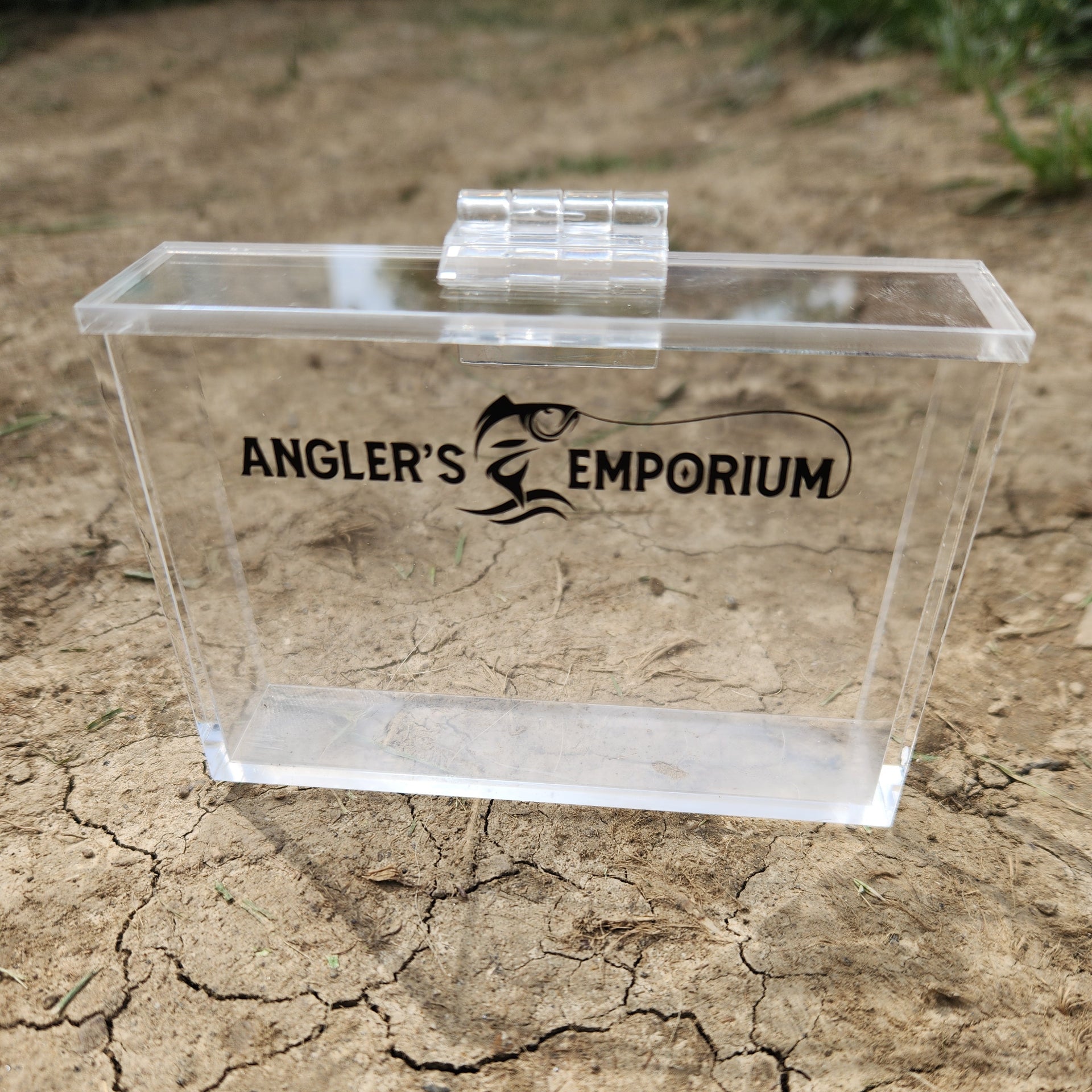 Clear acrylic block with 'Angler's Emporium' logo on a textured stone background