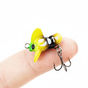  Mad Bee Micro  fishing lure shown on a person's fingers against a white background.