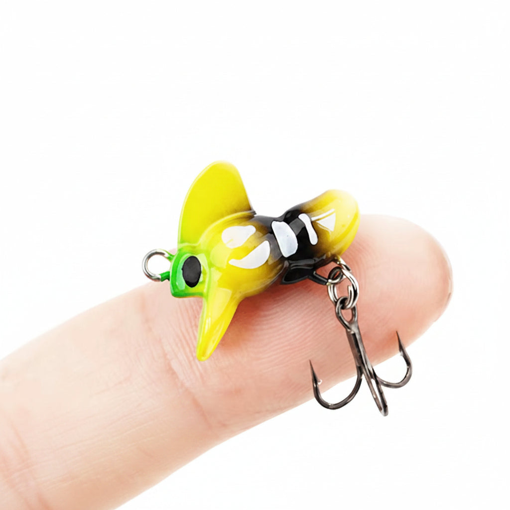  Mad Bee Micro  fishing lure shown on a person's fingers against a white background.