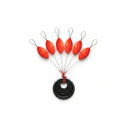 Set of red fishing floats attached to a black weight on a white background
