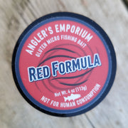 Red Formula fishing bait container lid on a wooden surface
