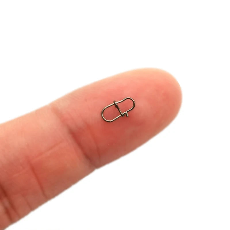 Small metal clasp on a person's finger against a white background