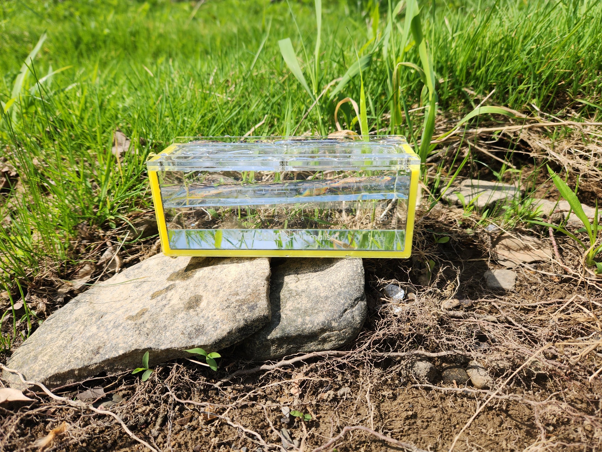 yellow micro fishing photo box on rock